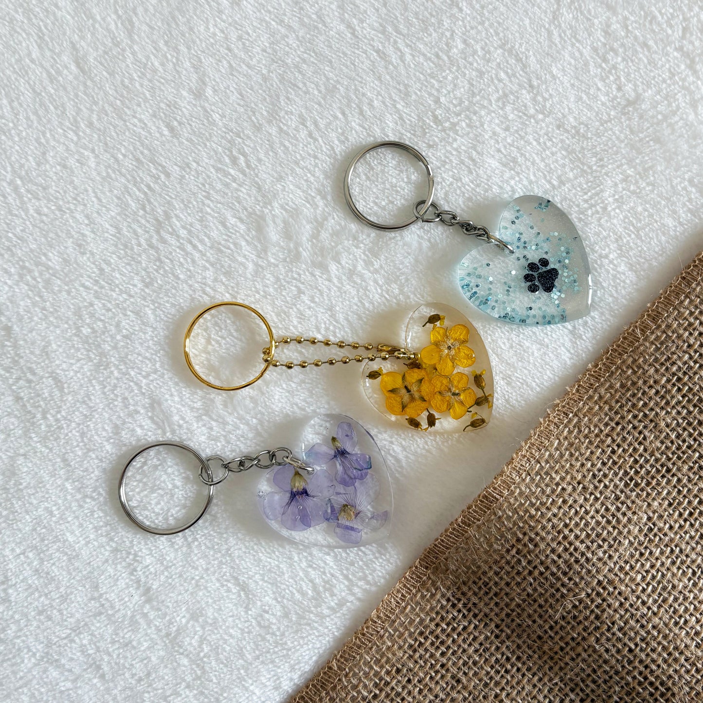 Handmade clear resin keyring with purple flowers in heart shape