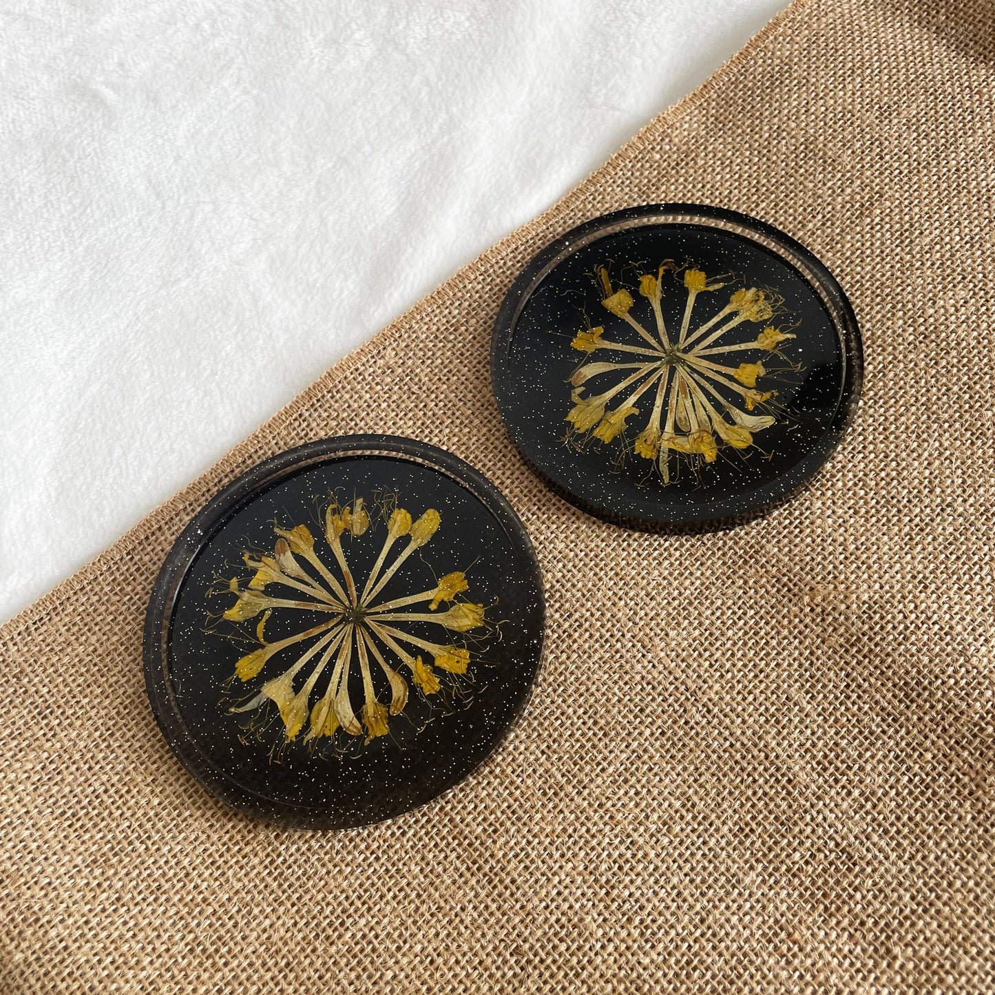 Slightly transparent black resin coaster with yellow flower centre, handmade décor gift