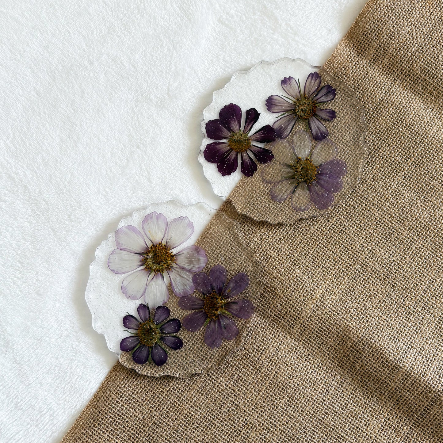 Clear resin coaster with embedded purple flowers, nature-inspired handmade décor piece