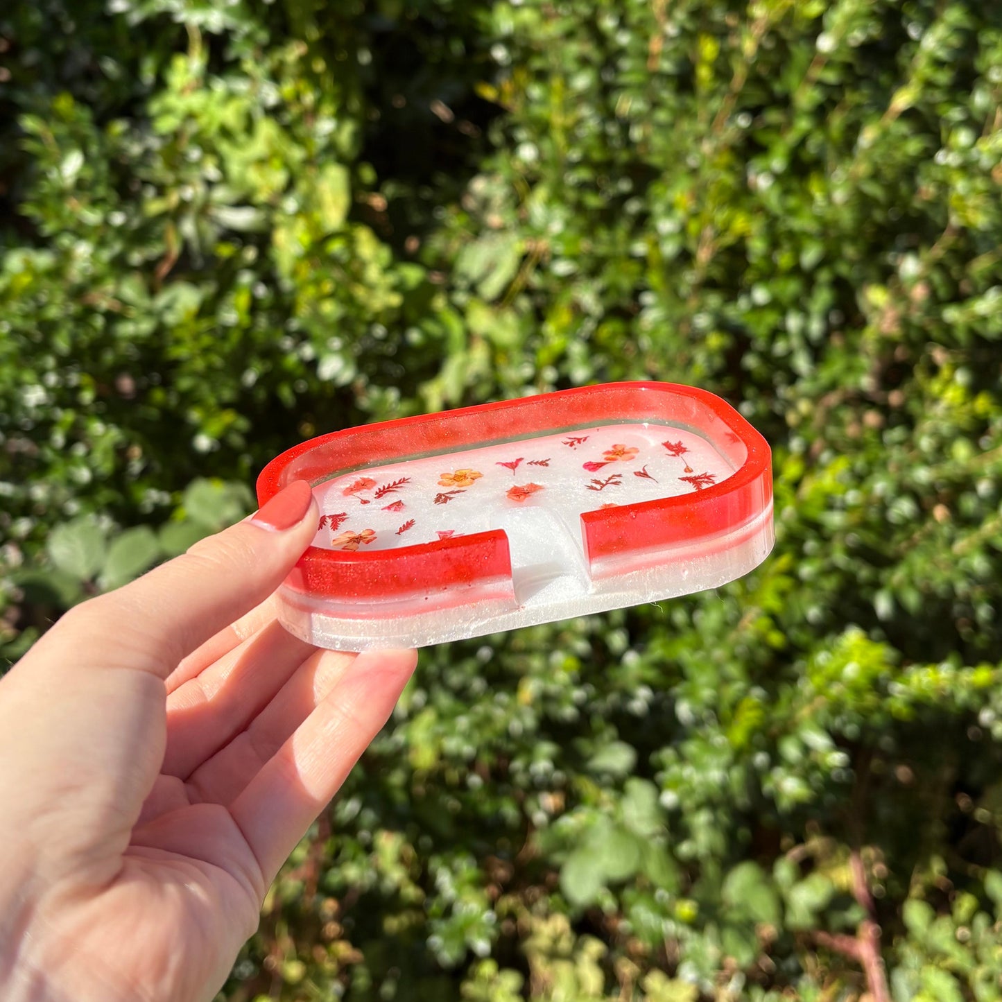 White resin soap dish with red rim and flower accents