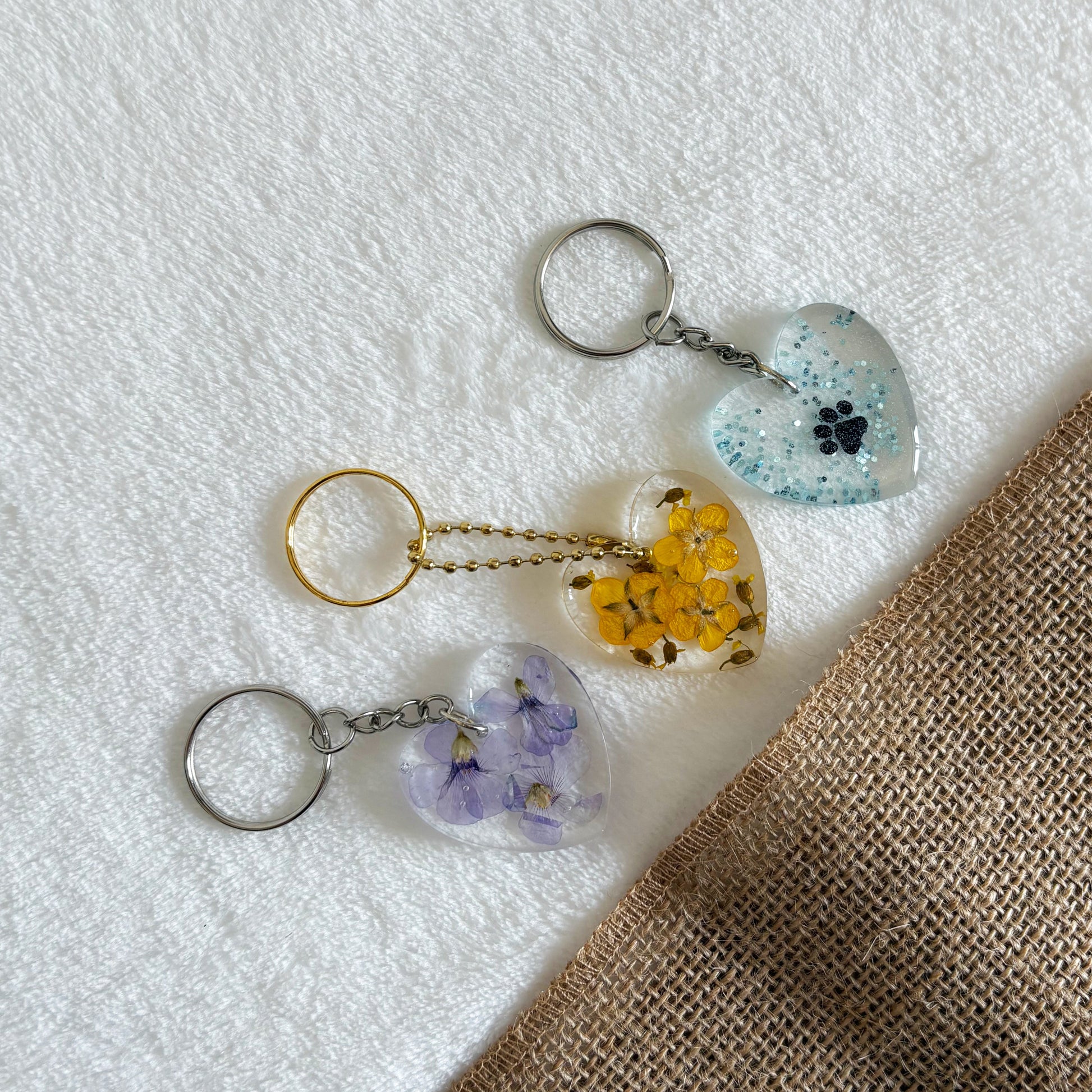Handmade clear resin keyring with purple flowers in heart shape