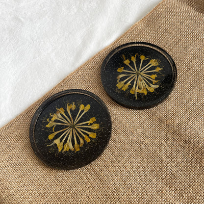 Slightly transparent black resin coaster with yellow flower centre, handmade décor gift