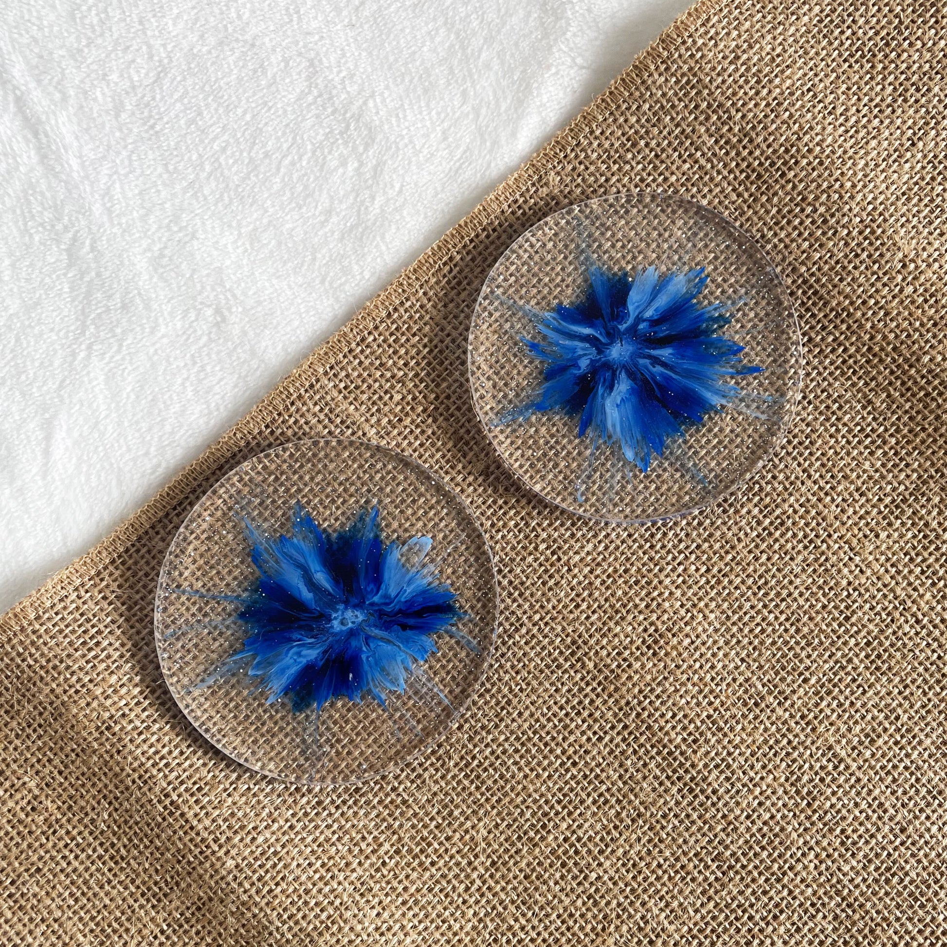 Handmade resin coaster with blue marbling radiating from centre, one-of-a-kind décor piece